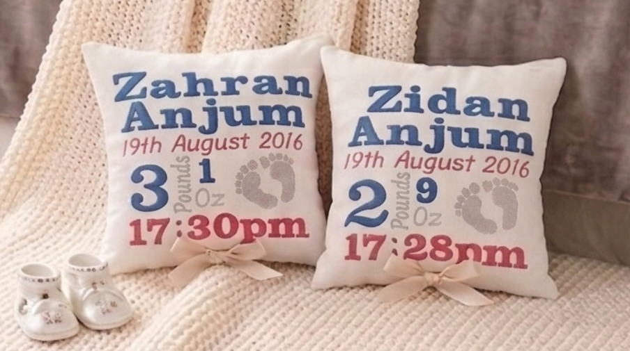 Close-up of personalised blue and red embroidered baby birth announcement cushion by Your Gifted.